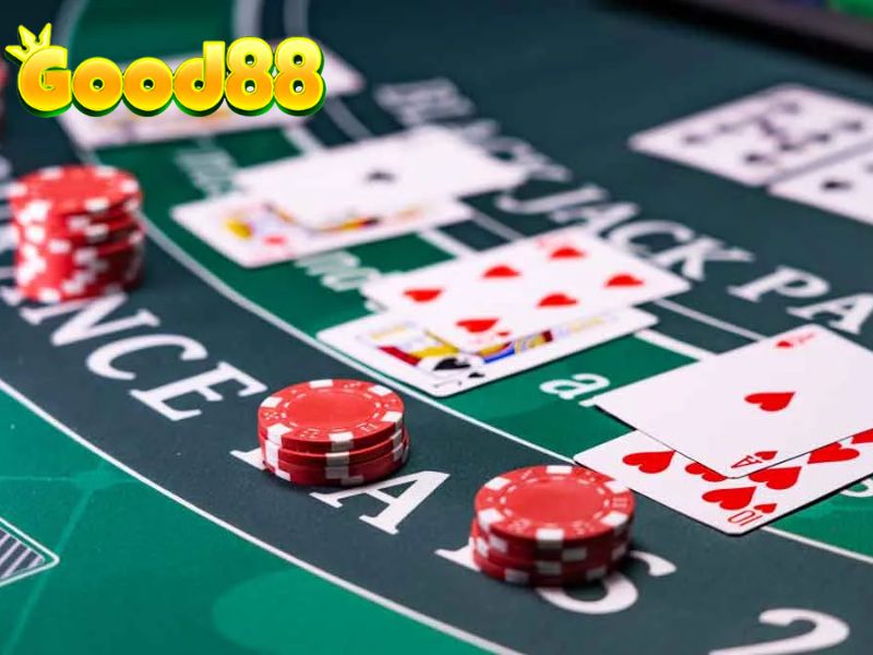 Bàn Blackjack với các tay bài đã mở và chồng chip cược.
